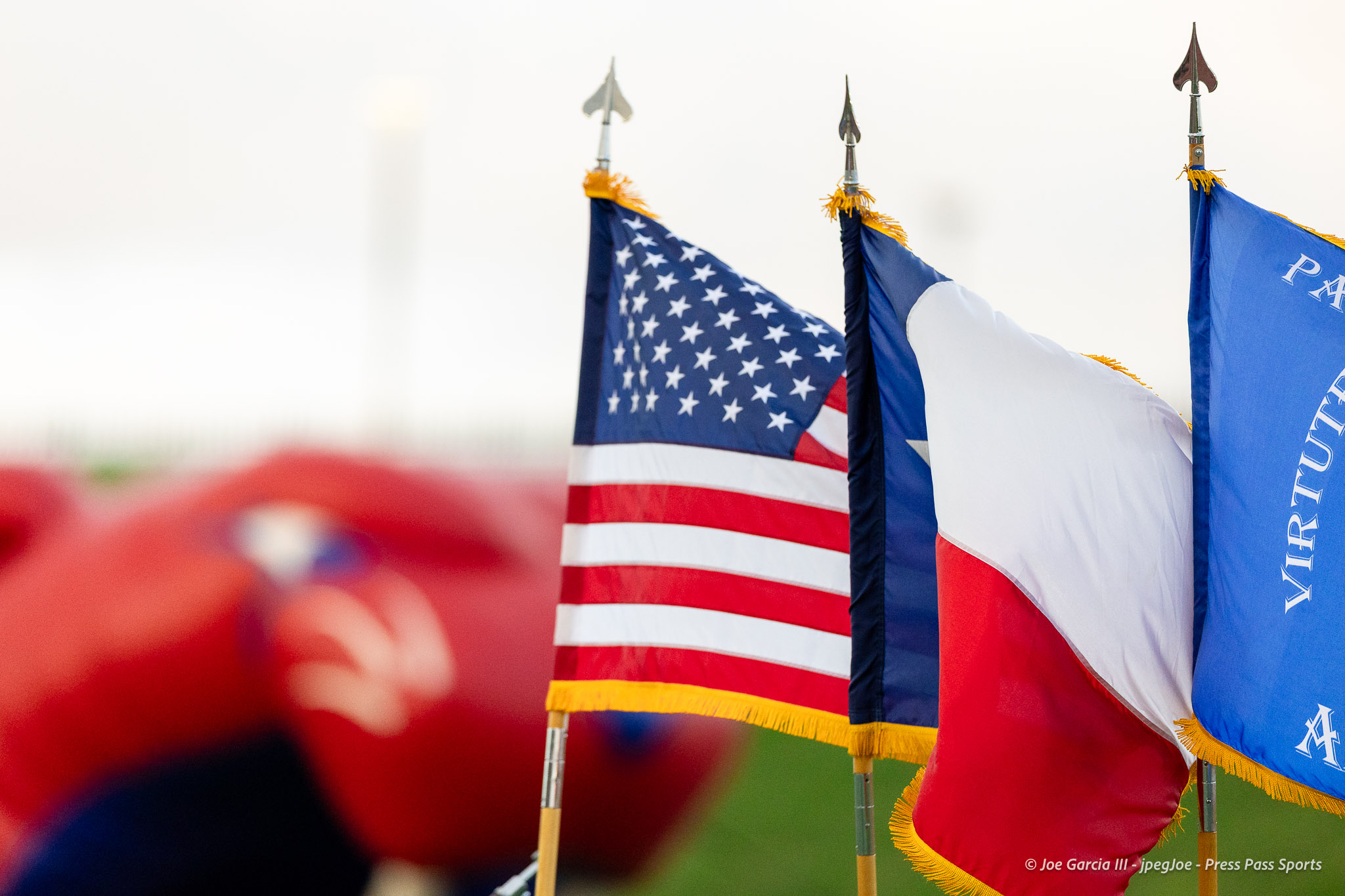 abilene-cooper-vs-palo-duro-jpegJoe-pps-1 | Press Pass Sports American flag beside blue and white flags on flagpoles at a parade event