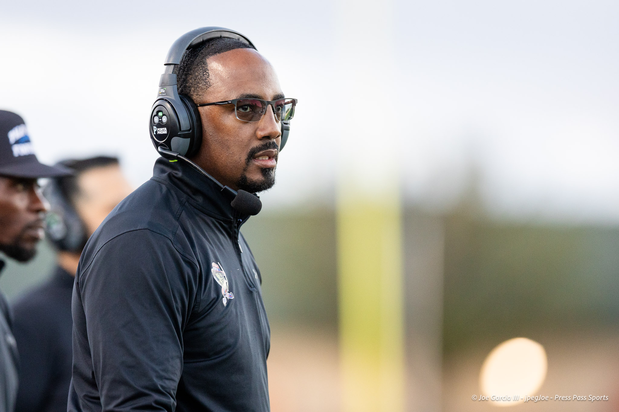 abilene-cooper-vs-palo-duro-jpegJoe-pps-5 | Press Pass Sports Man wearing over-ear headset with microphone, looking off to the right in a dark jacket.