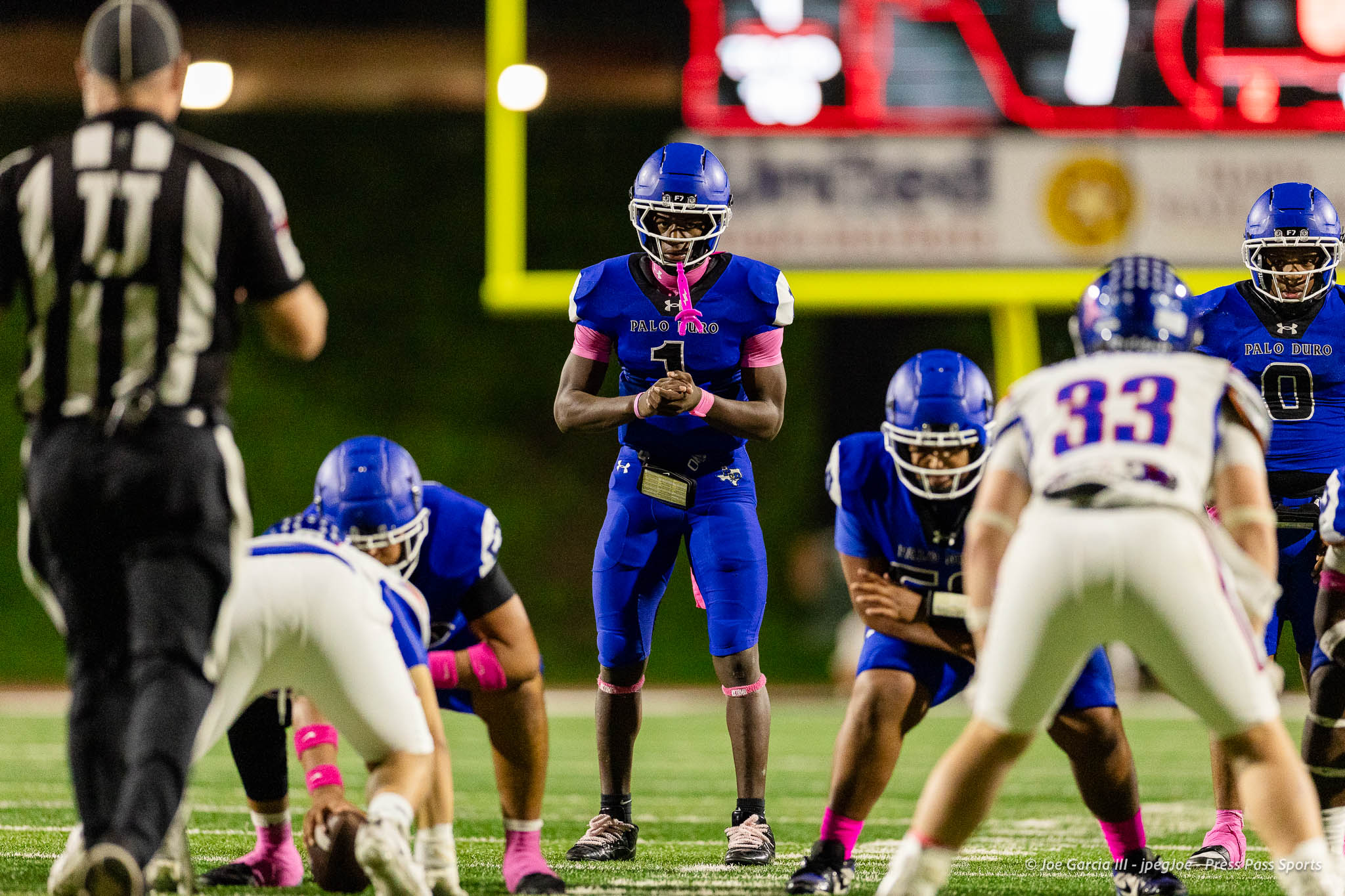 abilene-cooper-vs-palo-duro-jpegJoe-pps-27 | Press Pass Sports Football players from Palo Duro line up at the line of scrimmage on a night game, center ready to snap the ball, referee on left.