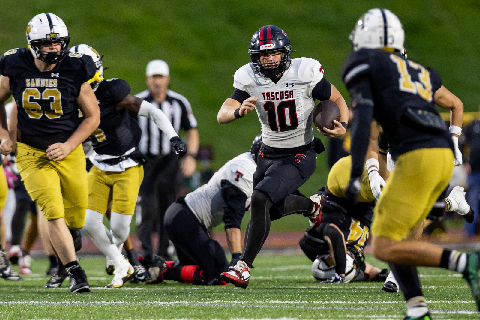 THS-AHS-FB-15 | Press Pass Sports Tascosa quarterback #10 carries the ball up the field as Sandies players chase him on a night game on the turf field.