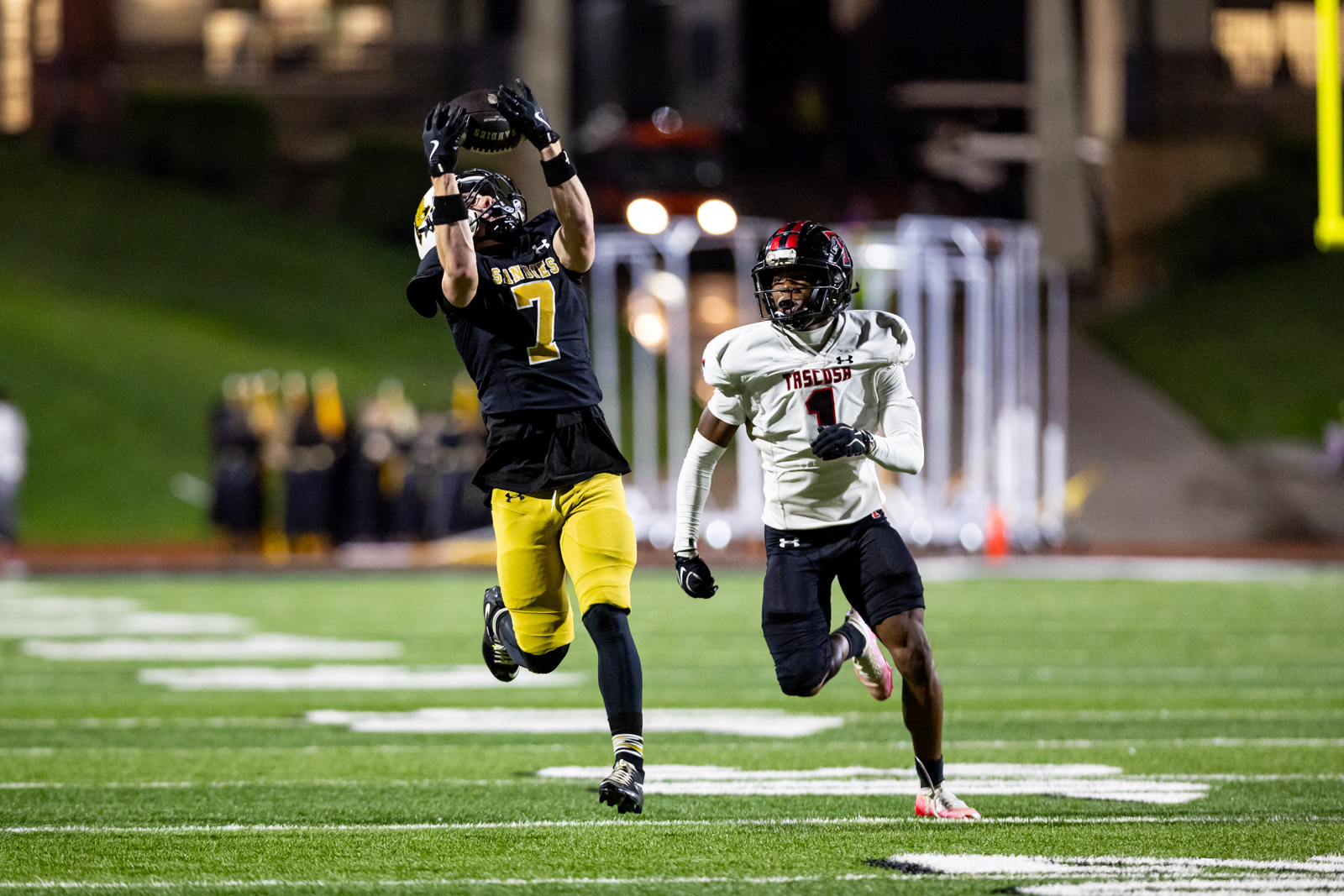THS-AHS-FB-38 | Press Pass Sports Football player in black and yellow leaps to catch a ball as a white-jersey opponent (#1) pursues.