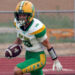 100326 - New Deal vs Sunray - Jacobi Creek | Press Pass Sports Football player in green and gold uniform runs with the ball on a track field ground surface in action.