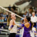 west-plains-vs-canyon-volleyball-jpegJoe-19 | Press Pass Sports Two female volleyball players celebrate with a high-five at the net during a match, one in white and one in purple, with a cheering crowd in the background.