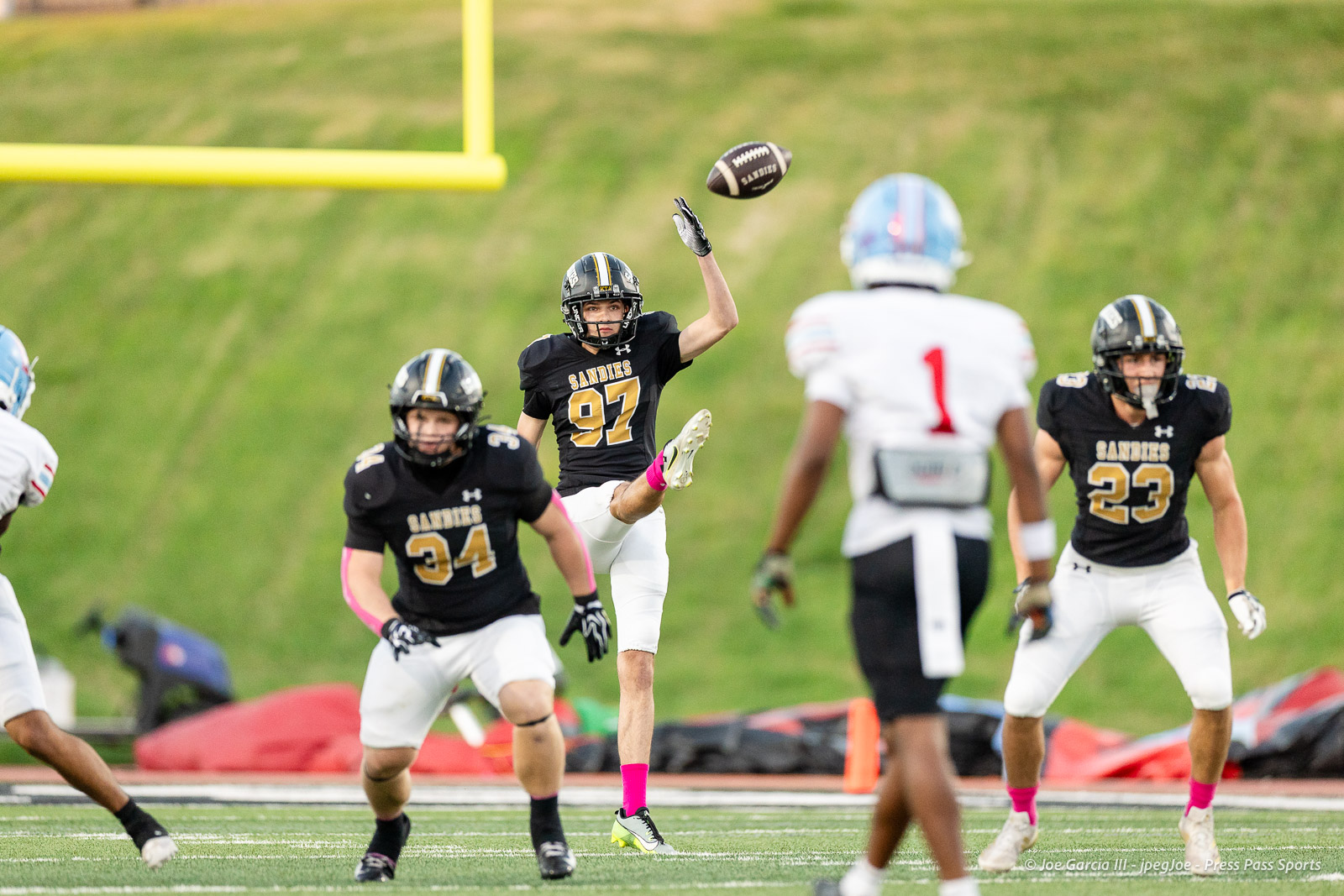 lubbock-monterey-vs-amarillo-high-football-jpegJoe-pps-6 | Press Pass Sports Sandies player #97 leaps to catch a football midair as teammates and opponents converge on the field during a game.