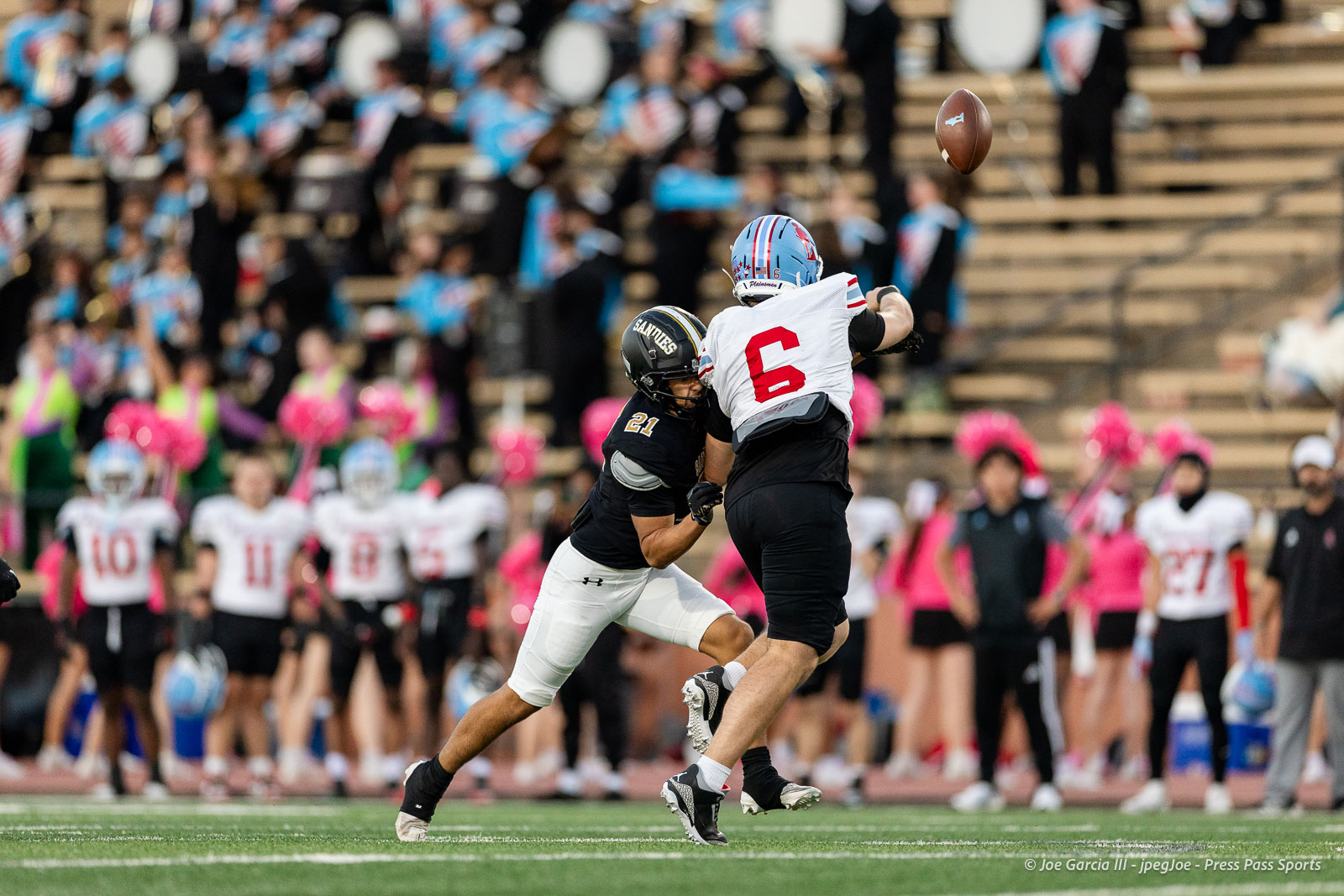 lubbock-monterey-vs-amarillo-high-football-jpegJoe-pps-11 | Press Pass Sports Two American football players leap for a pass: white jersey #6 vs. black jersey defender #21, with a crowded stadium in the background.