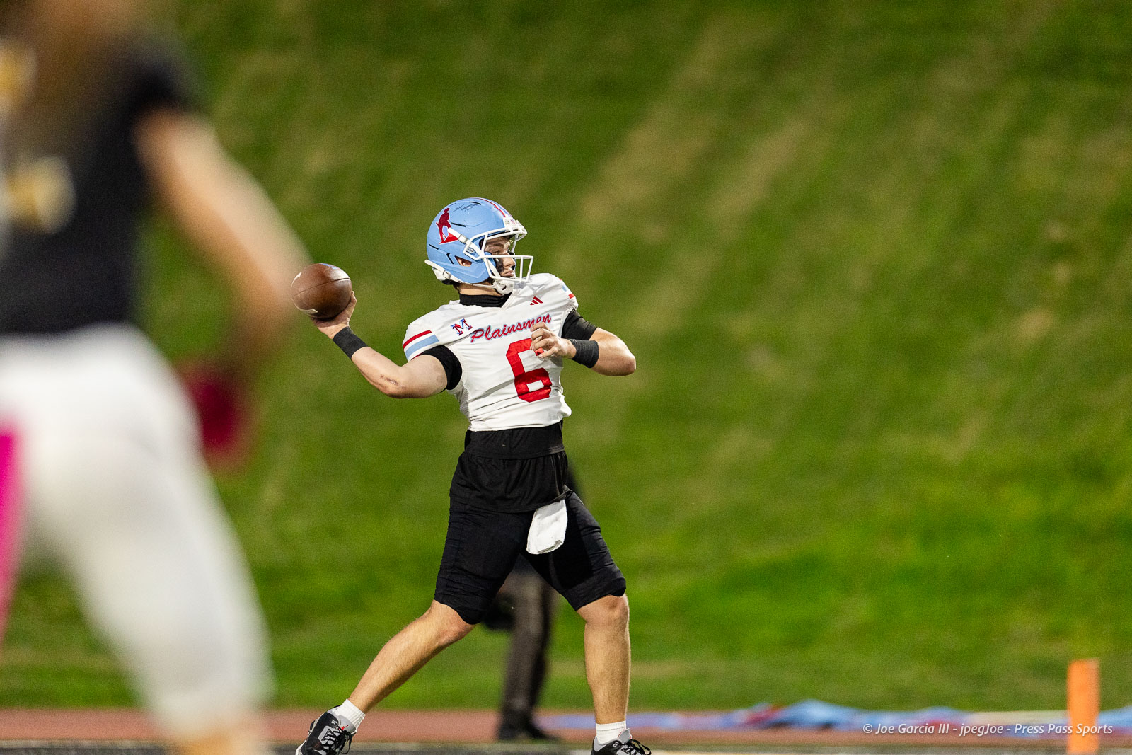 lubbock-monterey-vs-amarillo-high-football-jpegJoe-pps-14 | Press Pass Sports Quarterback in white jersey with red number 6 throws a football on a grassy field, blue helmet mid‑throw under stadium lights