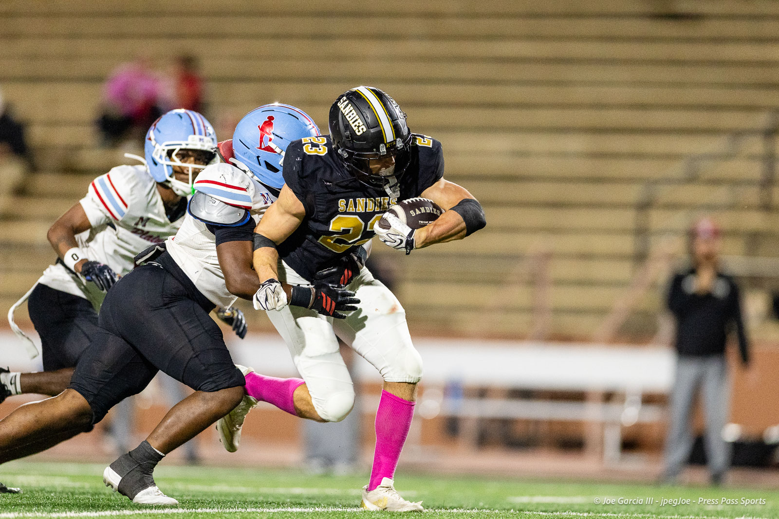 lubbock-monterey-vs-amarillo-high-football-jpegJoe-pps-29 | Press Pass Sports Sandies running back in black jersey (#23) carries the ball while being chased by defenders on a turf field.