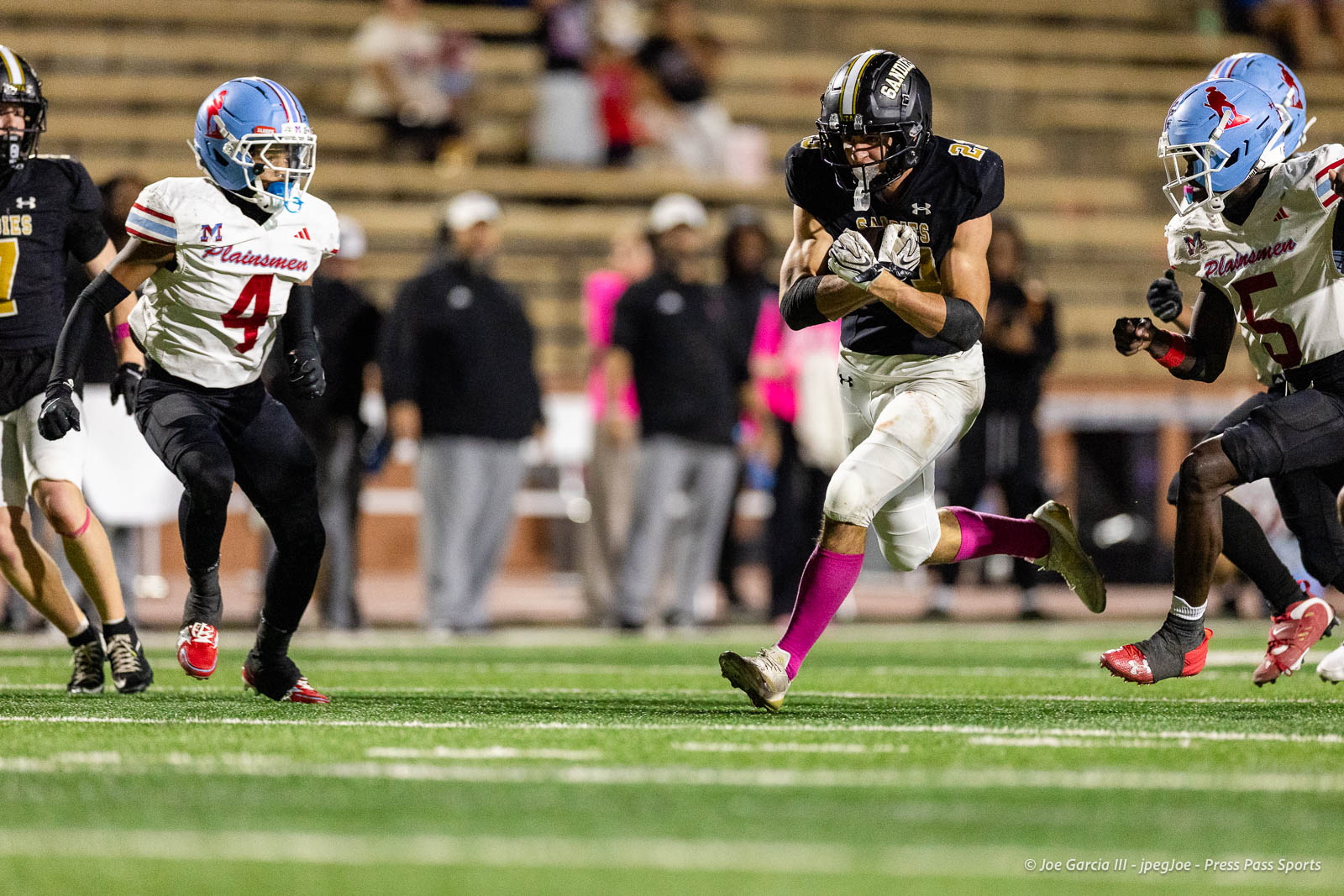 lubbock-monterey-vs-amarillo-high-football-jpegJoe-pps-33 | Press Pass Sports A football player in a black jersey runs with the ball as opponents in white jerseys pursue on a turf field.
