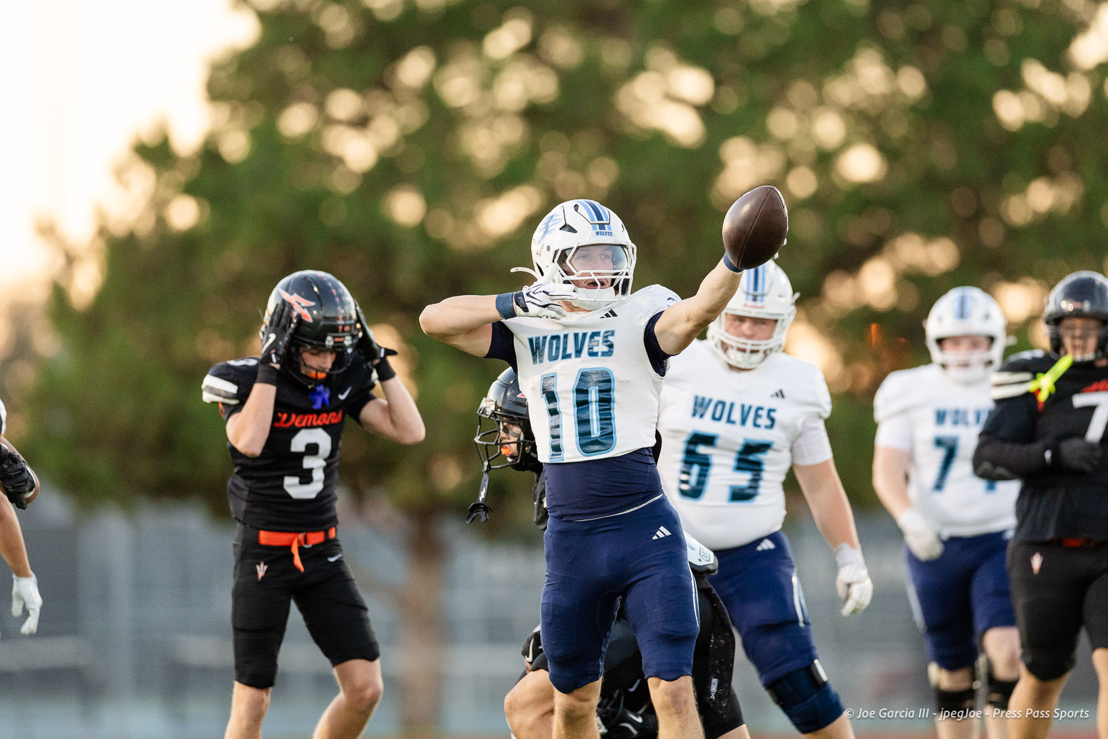 west-plains-vs-dumas-football-jpegJoe-pps-6 | Press Pass Sports White Wolves player #10 leaps to catch a pass during a sunny football game, with teammates and opponents nearby in action around him on the field.