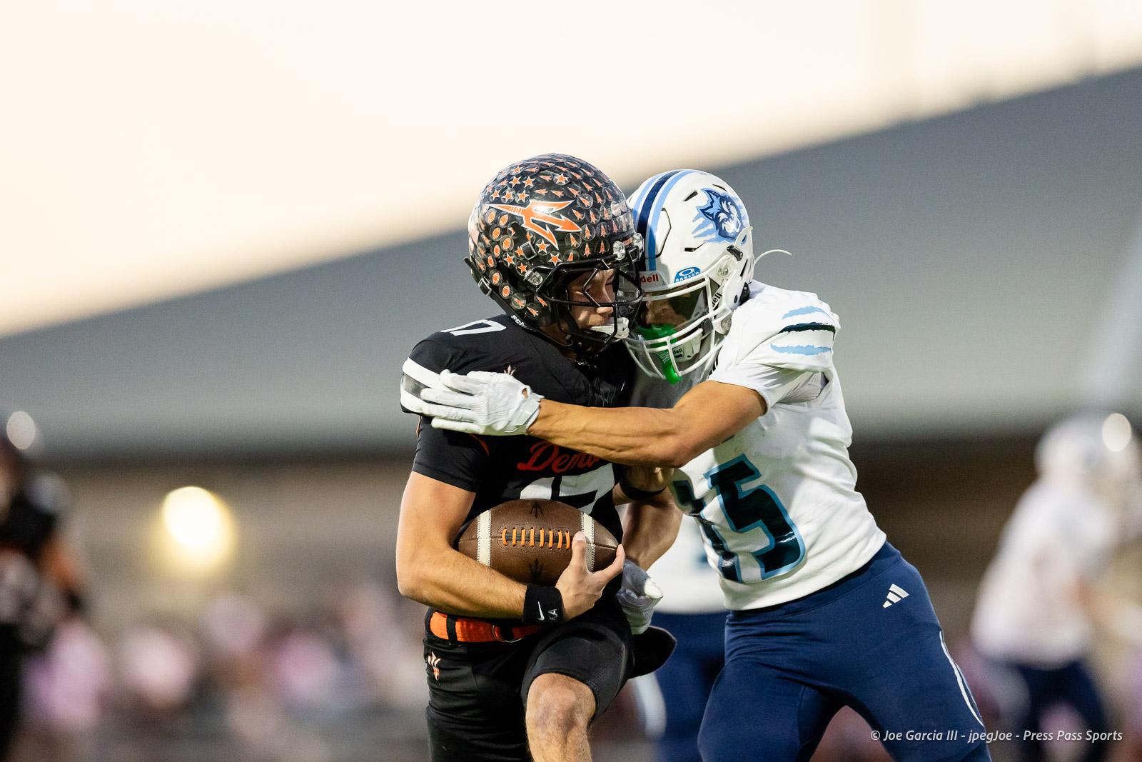 west-plains-vs-dumas-football-jpegJoe-pps-13 | Press Pass Sports Two football players collide as the ball carrier in black grips the ball while a defender in white tackles him.