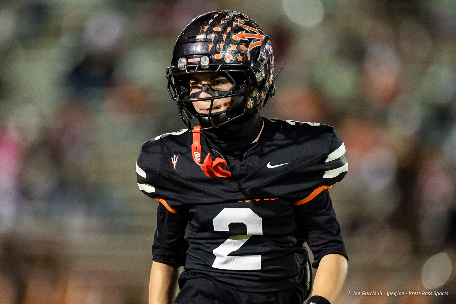 west-plains-vs-dumas-football-jpegJoe-pps-33 | Press Pass Sports Football player in black jersey number 2 on a field, wearing a decorated black helmet and orange lanyard with whistle.