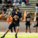 west-plains-vs-dumas-football-jpegJoe-pps-36 | Press Pass Sports Quarterback in a black uniform runs with the football, looking downfield during a game on a lit field.