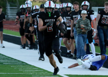 Stratford vs Gruver - Mason Lankford | Press Pass Sports Gruver football player with number 2 runs with the ball along the sideline, teammates in pursuit behind him, on a football field.