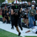 Stratford vs Gruver - Mason Lankford | Press Pass Sports Gruver football player with number 2 runs with the ball along the sideline, teammates in pursuit behind him, on a football field.