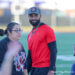 IMG_2467 | Press Pass Sports Bearded man in a red athletic shirt and cap among a group on a sports field.