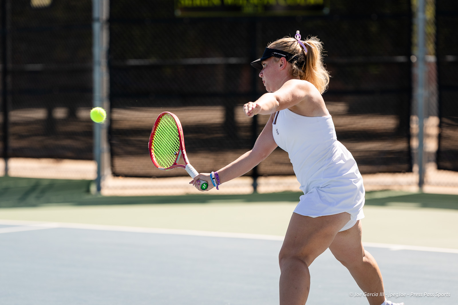 canyon-regional-tennis-79 | Press Pass Sports Female tennis player in a white dress swings at a ball on an outdoor court, racket ready for a forehand.