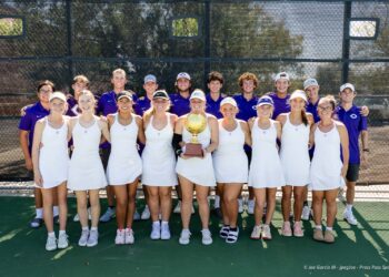canyon-regional-tennis-107 | Press Pass Sports Tennis team posing on the court with a gold trophy; front row in white dresses, back row in purple uniforms.