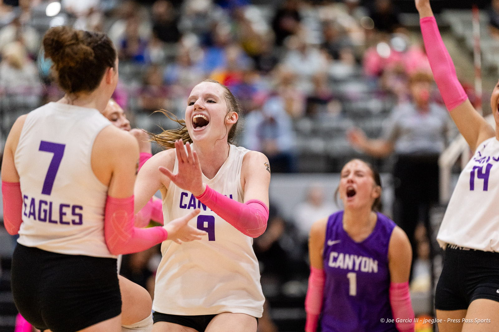 canyon-vs-west-plains-2026-38 | Press Pass Sports Female basketball players celebrate on the court; central player in white jersey #9 cheers with raised hands as teammates cheer nearby.
