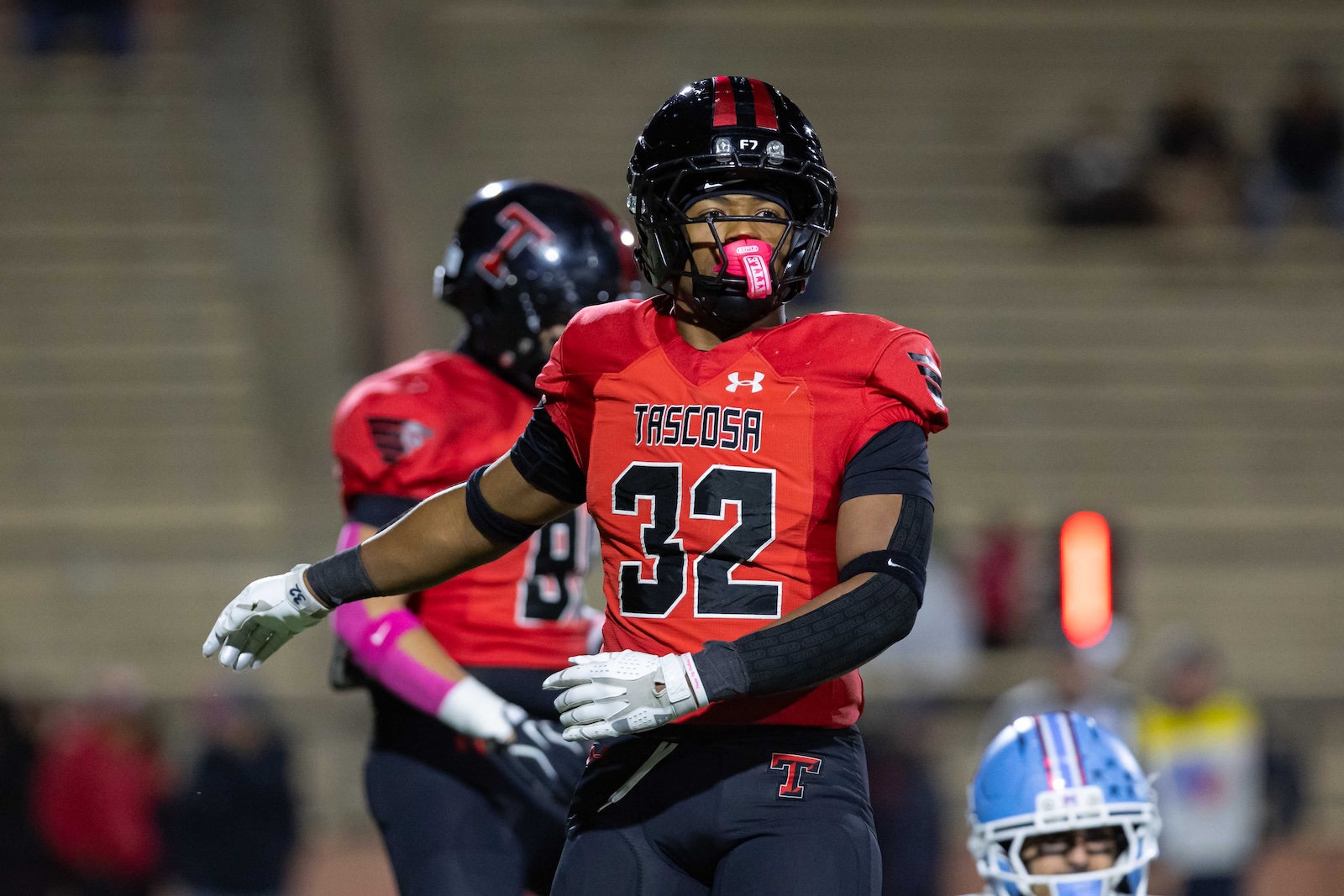 MHS-THS-FB-23 | Press Pass Sports Football player in a red Tascosa jersey #32 with a black helmet and pink mouthguard on the field.