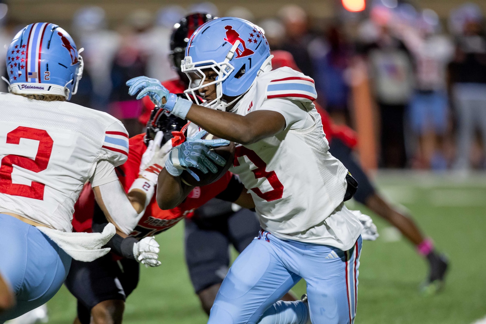 MHS-THS-FB-35 | Press Pass Sports Player in light-blue helmet and white jersey runs with the football during a tackle in progress.