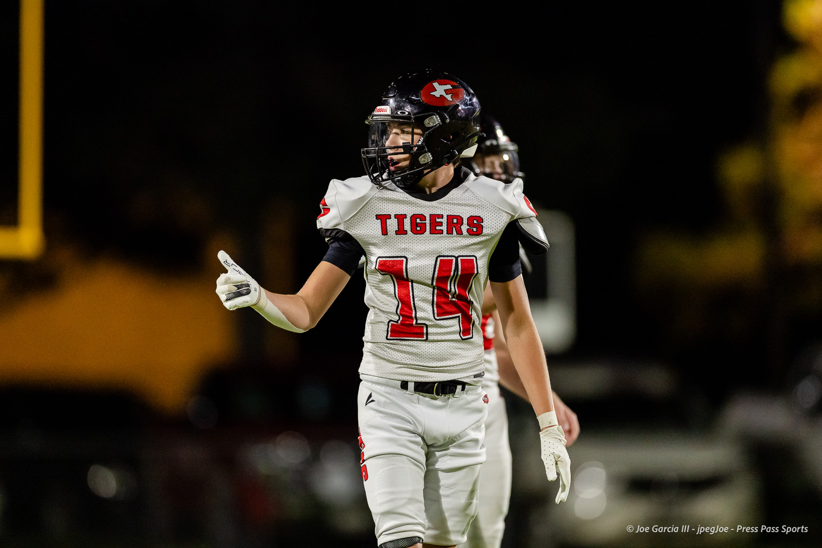 groom-vs-follett-football-jpegJoe-pps-13 | Press Pass Sports Football player in a white Tigers jersey with #14, giving a thumbs-up on a night game.