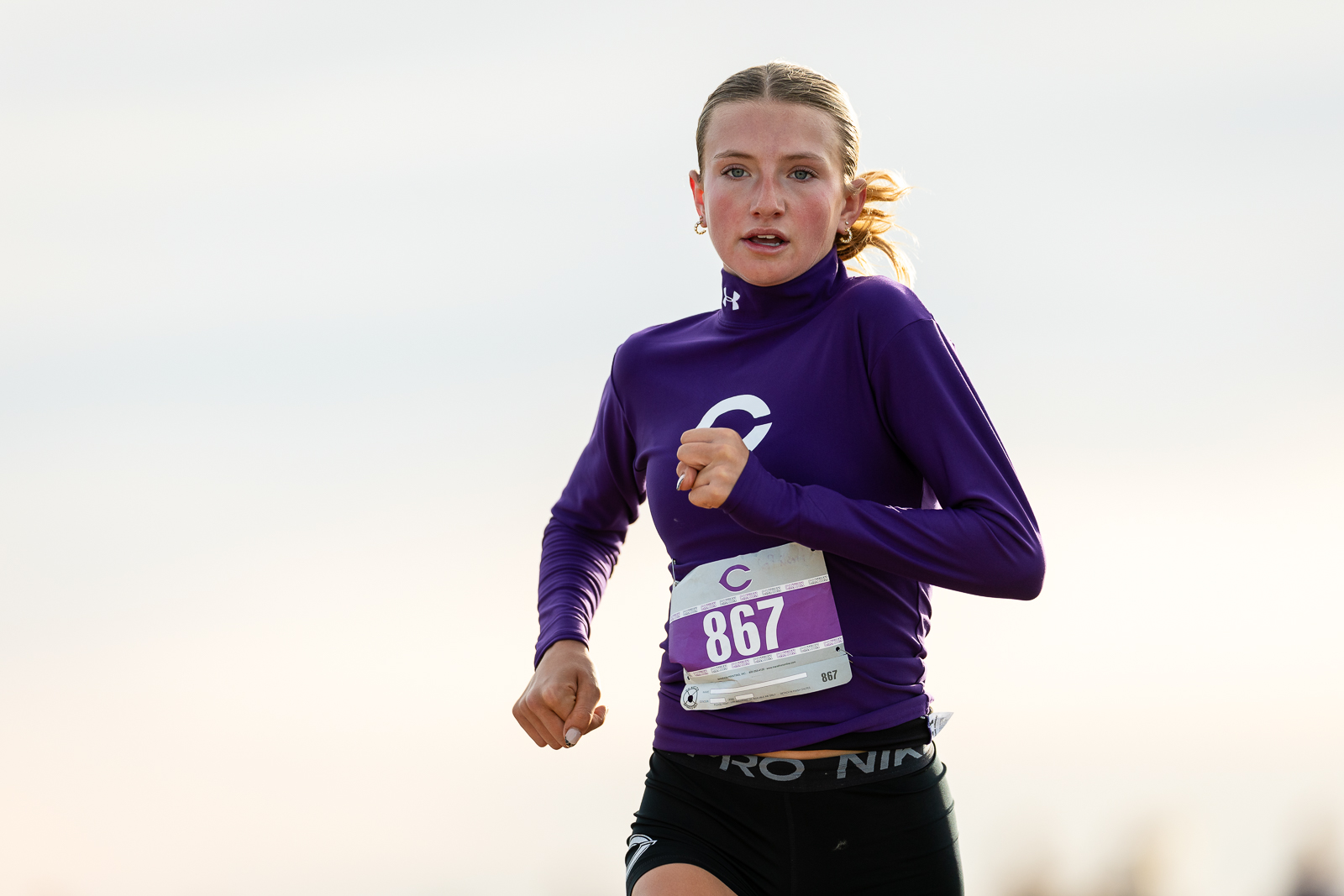 district-4a-canyon-xc-jpegJoe-pps-6 | Press Pass Sports Female runner in a purple long-sleeve top with bib 867, mid-race outdoors.