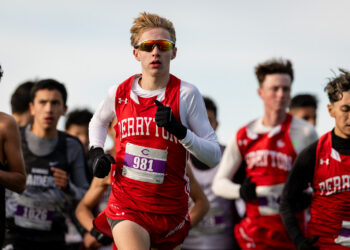 district-3a-4a-cross-country-jpegJoe-pps-73 | Press Pass Sports Young male runner in red and white uniform with bib 981 leading a cross-country race.