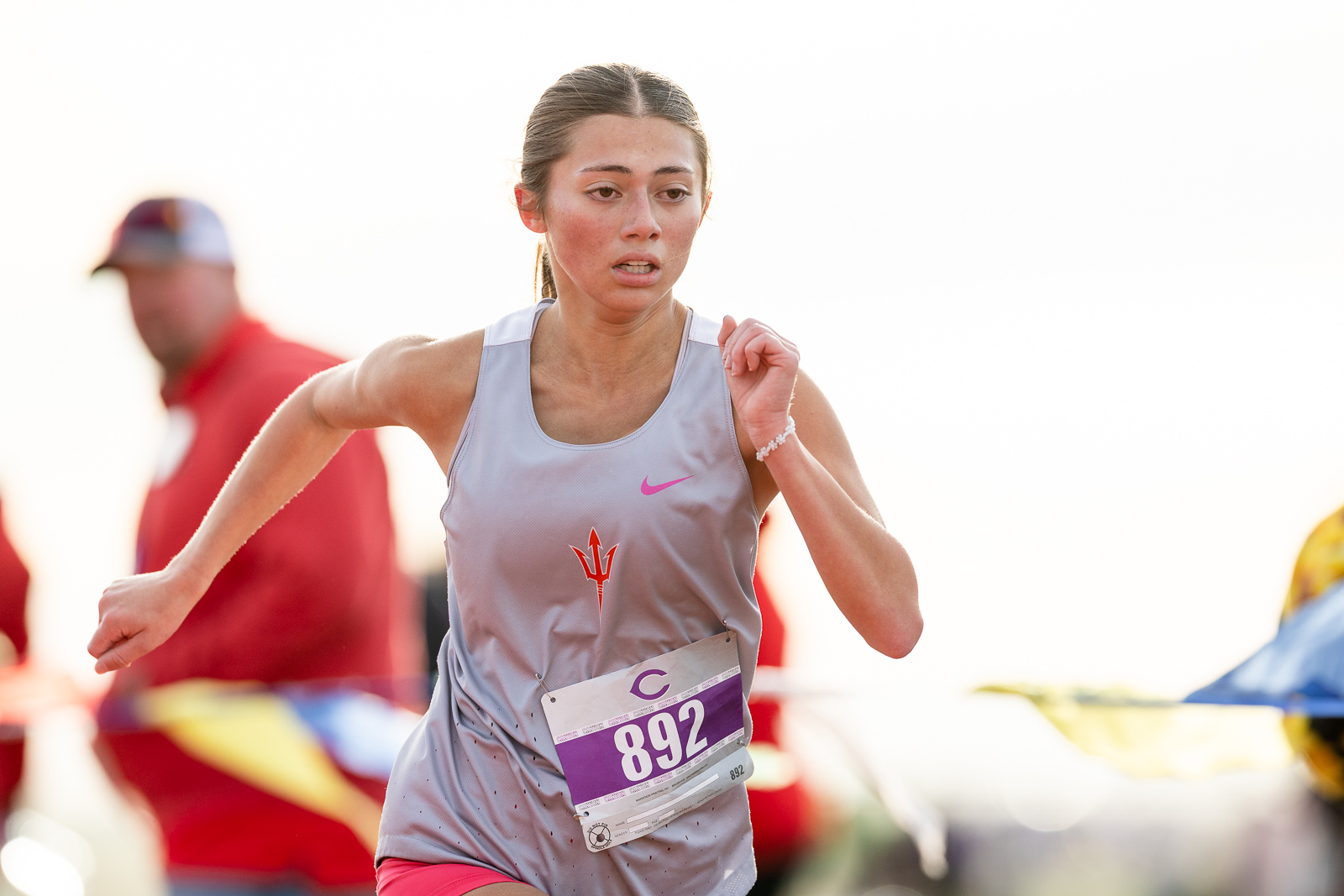 3A-4A-district-xc-jpegJoe-pps-24 | Press Pass Sports Female sprinter in a light gray sleeveless top running, bib number 892 visible at the front.