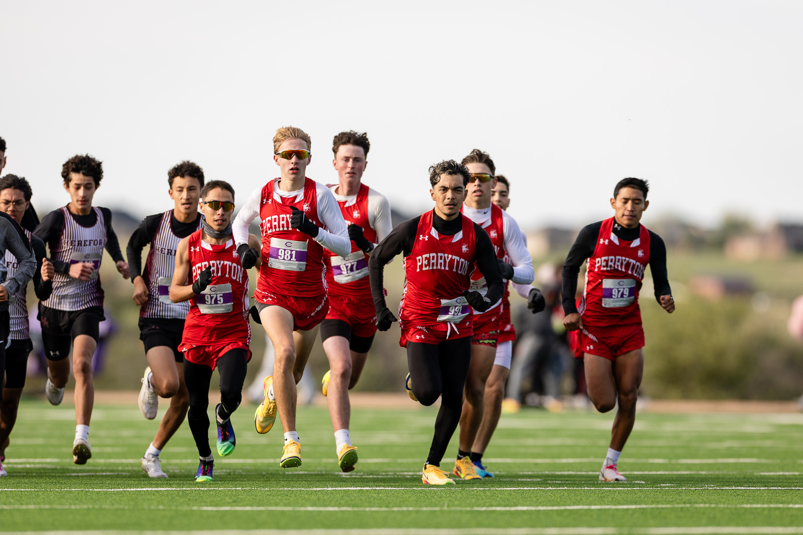 3A-4A-district-xc-jpegJoe-pps-32 | Press Pass Sports Runners in red Perryton uniforms race on a green track in a cross-country meet on a sunny day.