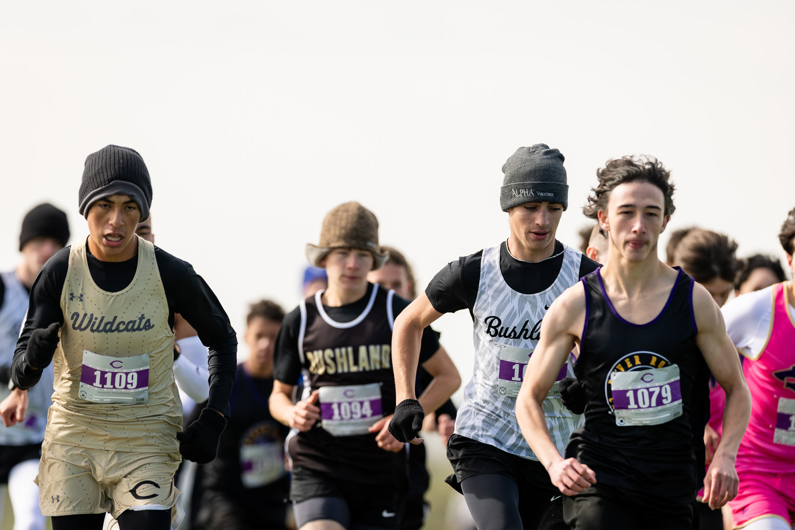 3A-4A-district-xc-jpegJoe-pps-90 | Press Pass Sports Group of young male runners sprinting in a race, front runners wearing bib numbers 1109 and 1079.