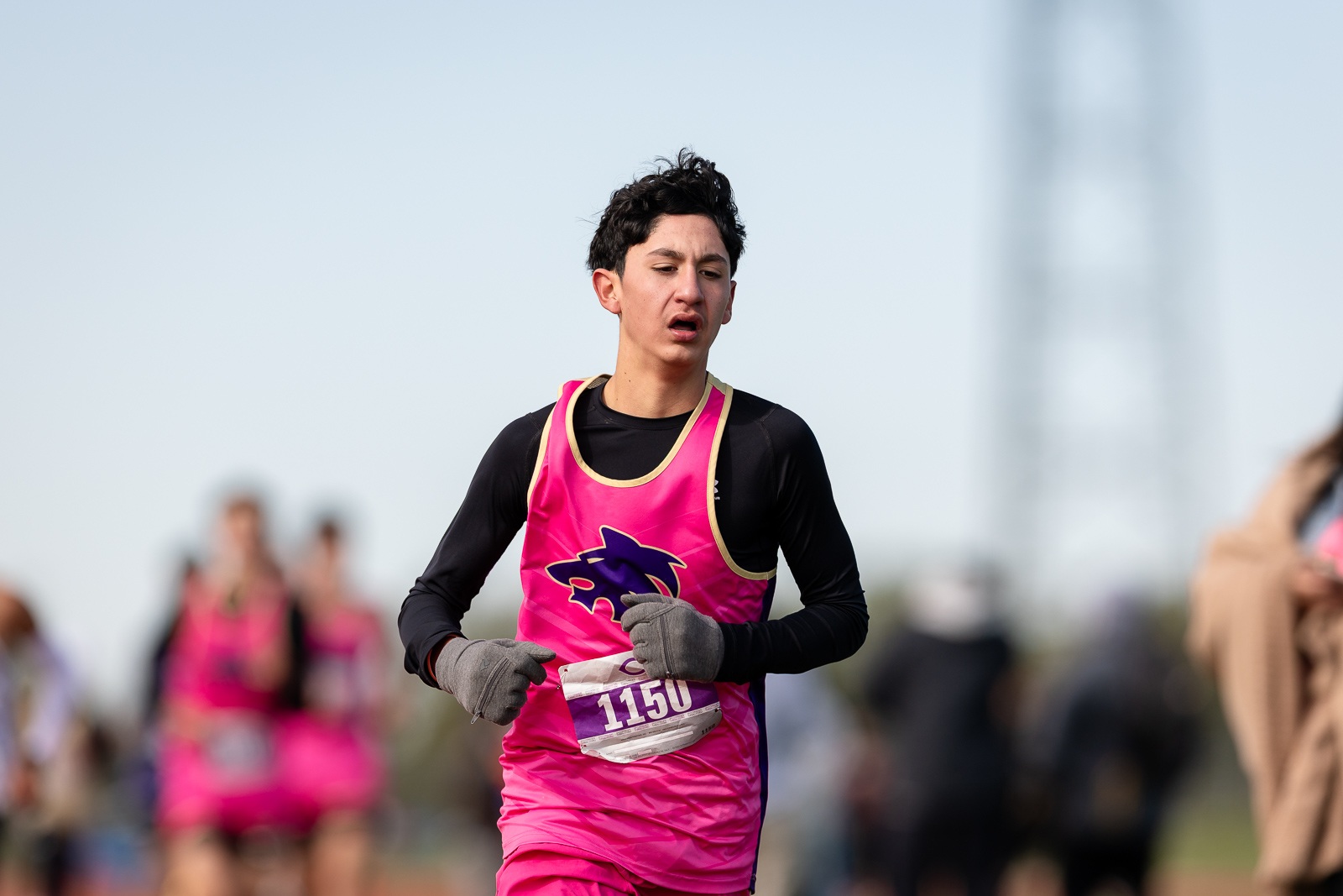 3A-4A-district-xc-jpegJoe-pps-94 | Press Pass Sports Young runner wearing a bright pink racing vest and gloves, bib number 1150, mid-race outdoors.