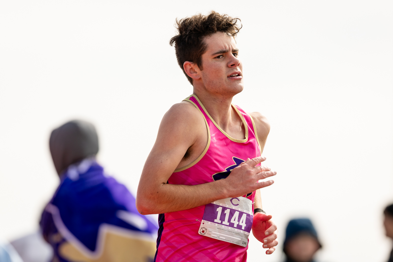 3A-4A-district-xc-jpegJoe-pps-100 | Press Pass Sports Male runner in a hot-pink racing singlet with bib 1144, mid-stride during a race.