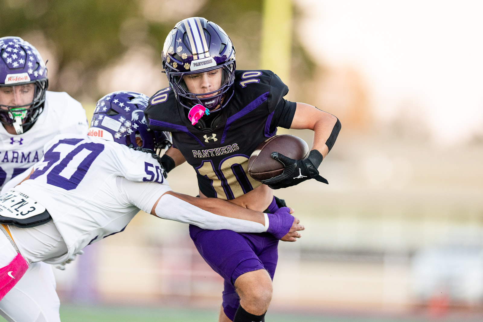 spearman-vs-panhandle-football-jpegJoe-pps-4 | Press Pass Sports Panthers running back in black and purple carries the ball as defenders close in.