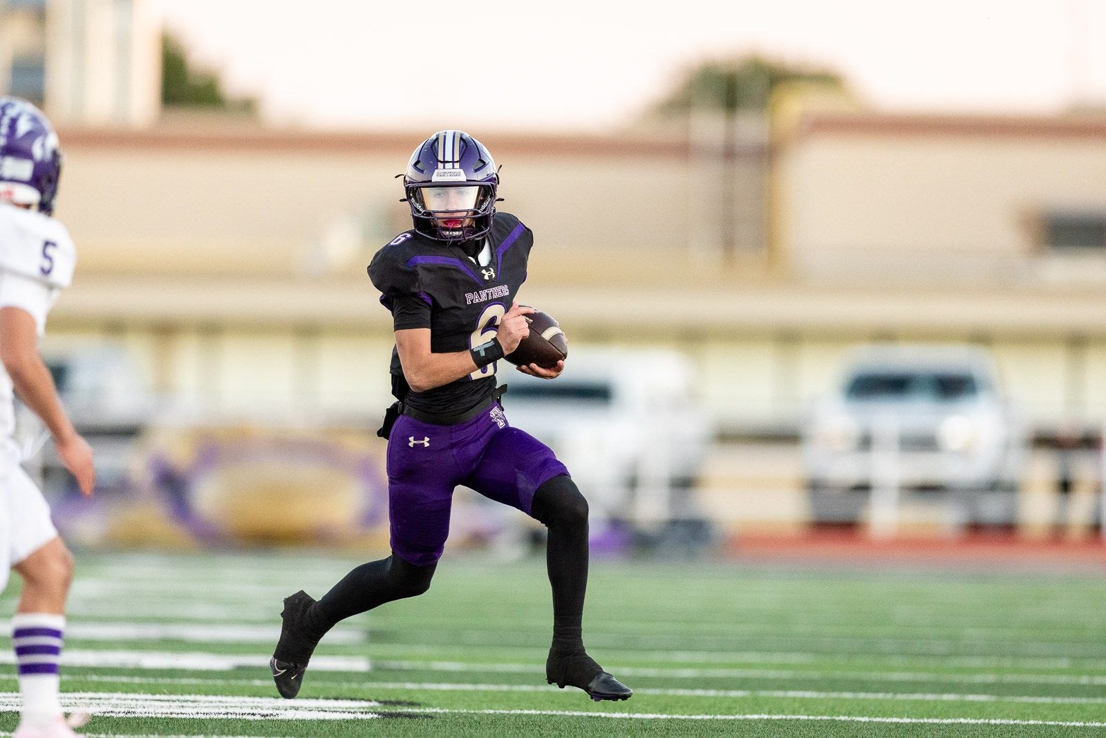 spearman-vs-panhandle-football-jpegJoe-pps-5 | Press Pass Sports Football player in purple and black runs with the ball on a green turf field during a game.