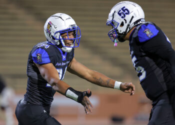 20261016-AWylie-PD-FB-022 | Press Pass Sports Two football players in blue and black uniforms collide mid‑play on the field.