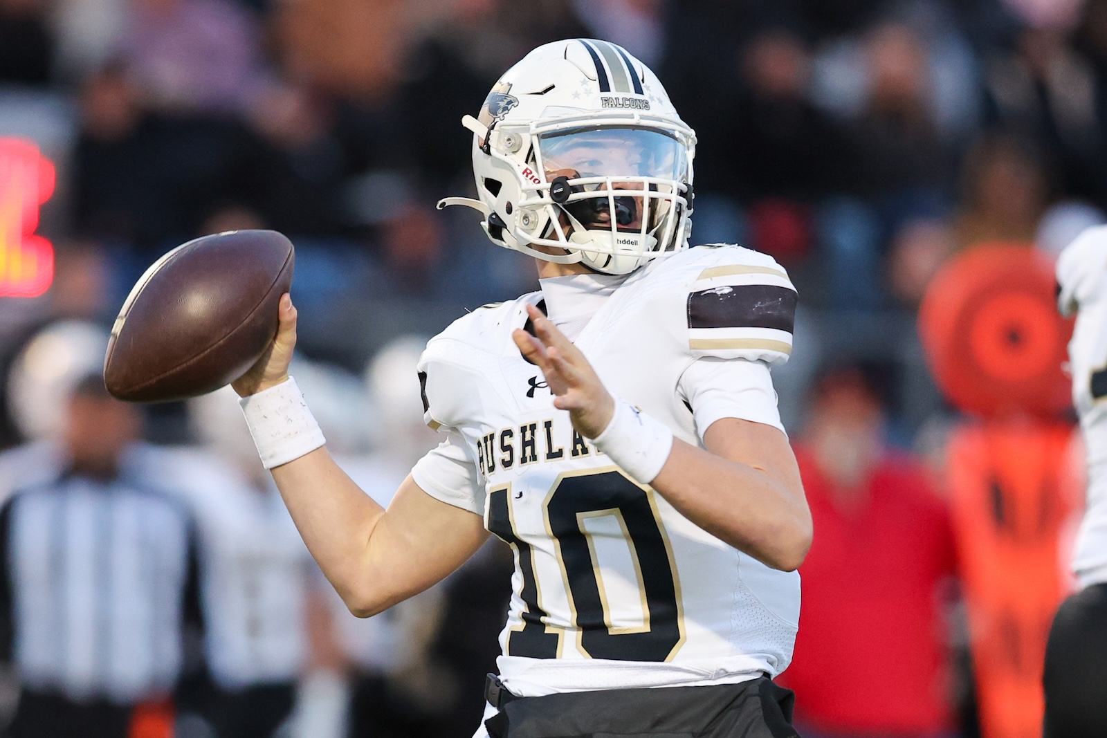 Seabolt Chase-16453 | Press Pass Sports Football quarterback in a white uniform prepares to throw a pass, wearing a Falcons helmet on the field.