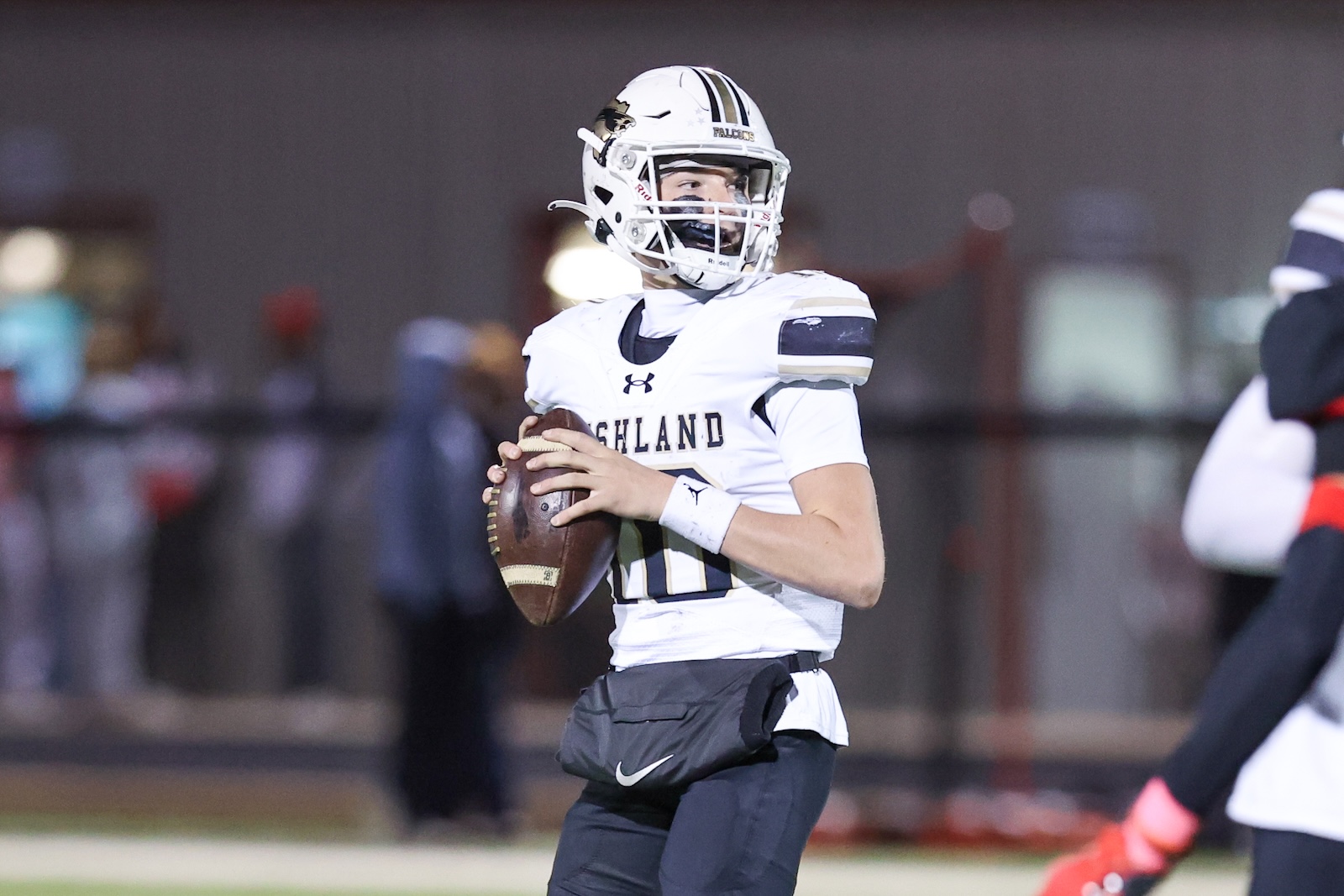 Seabolt Chase-17522 | Press Pass Sports Football quarterback in a white uniform holding a football and scanning the field during play.