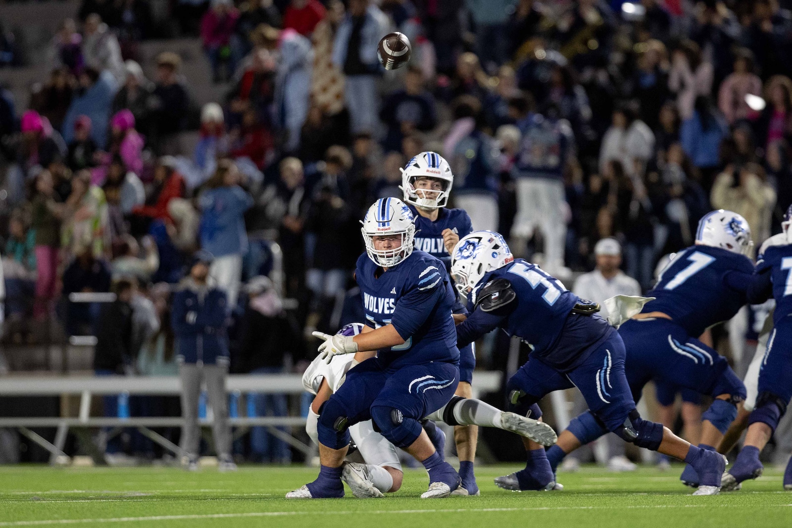 CHS-WPHS-FB-21 | Press Pass Sports American football game: QB in blue Wolverines jersey releases ball as teammates advance and blockers collide.