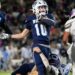 CHS-WPHS-FB-25 | Press Pass Sports Football player wearing navy jersey #10 runs with the ball as teammates and defenders battle nearby on the field