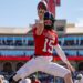 ASU-TTU-FB-11 | Press Pass Sports Football player in a red Red Raiders jersey leaps to catch a ball during a sunny game in a stadium.
