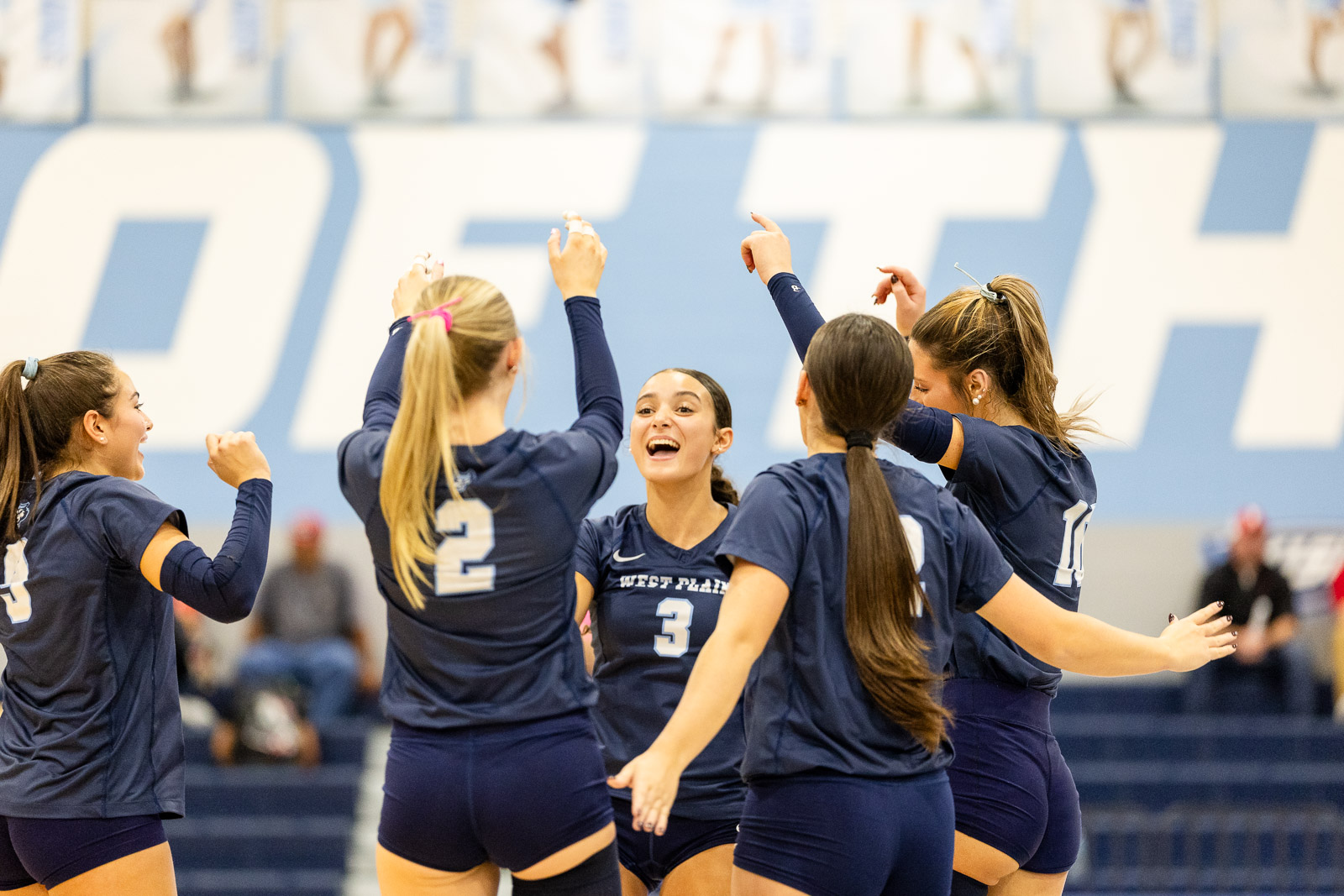 2026-wphs-senior-night-jpegJoe-2 | Press Pass Sports Women’s volleyball team in navy uniforms celebrate with raised arms in a gym.