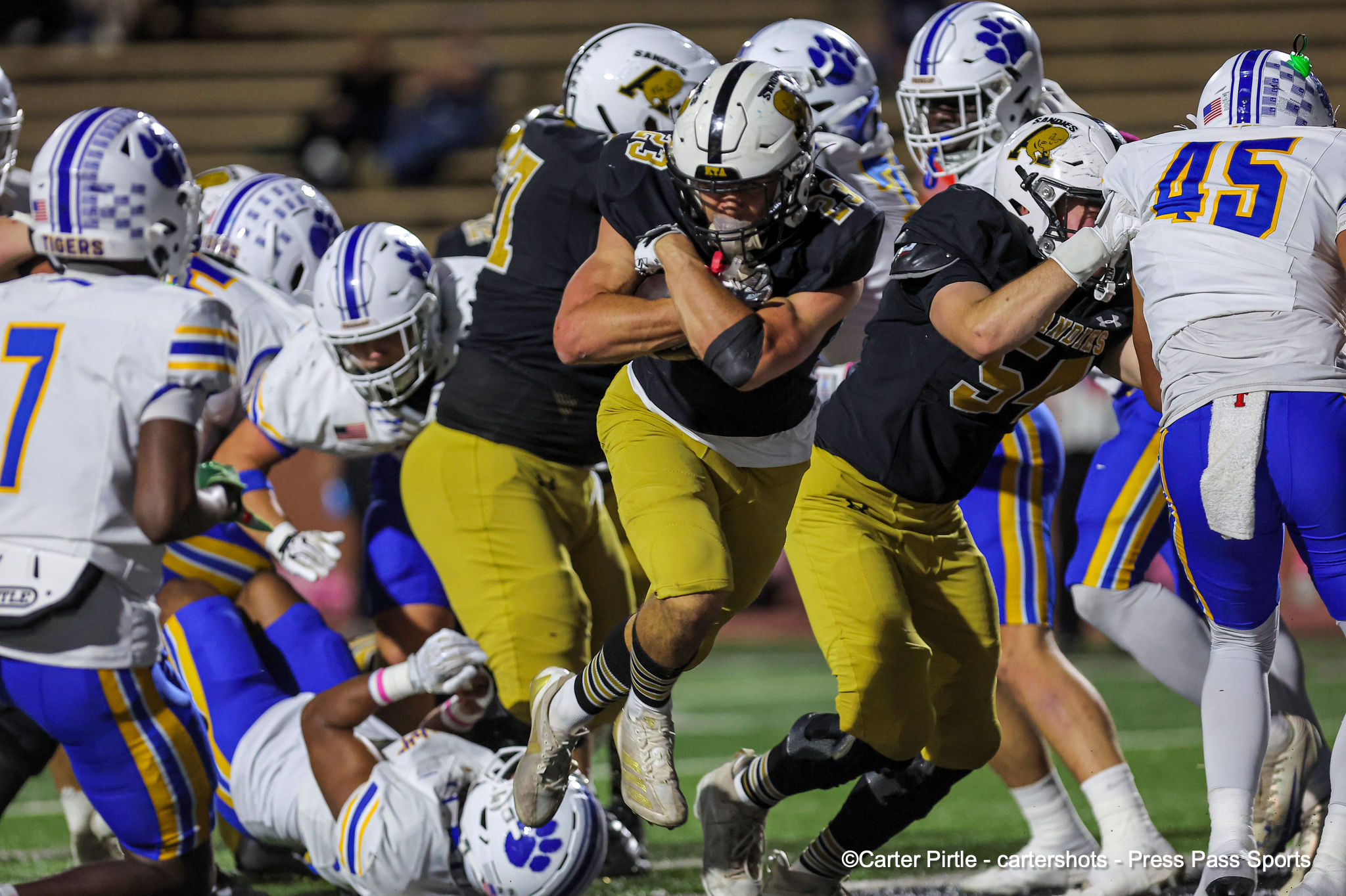 Football players collide at the line of scrimmage during a high‑action moment on the field.