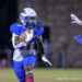 20261023-Claude-BR-FB-021 | Press Pass Sports American football player in blue and yellow jersey runs with the ball, evading a defender reaching in from the right.