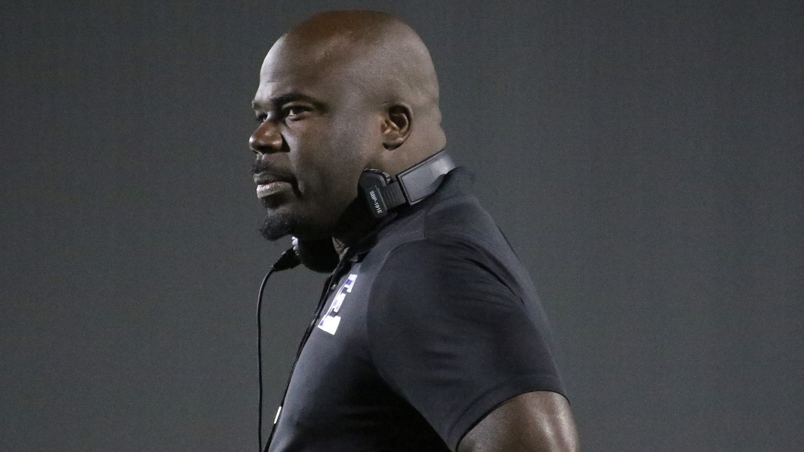 Side profile of a Black man wearing a DJ headset, looking to the left.