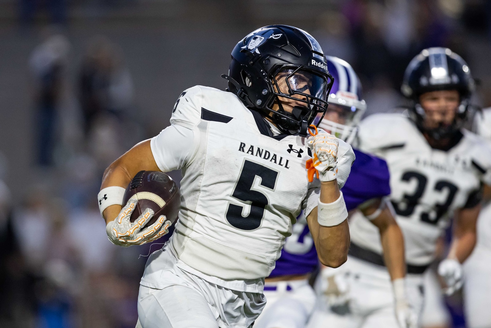 RHS-CHS-FB-5 | Press Pass Sports Randolph football player #5 runs with the ball during a game, wearing a white uniform and dark helmet.