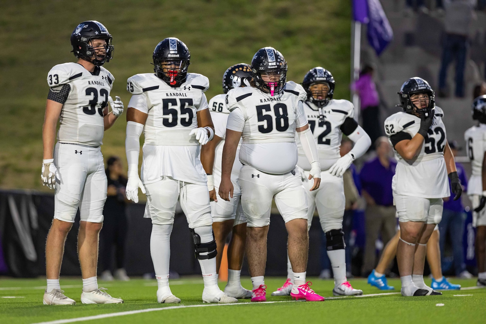 RHS-CHS-FB-6 | Press Pass Sports Randall football players in white uniforms stand together on the field during a game.