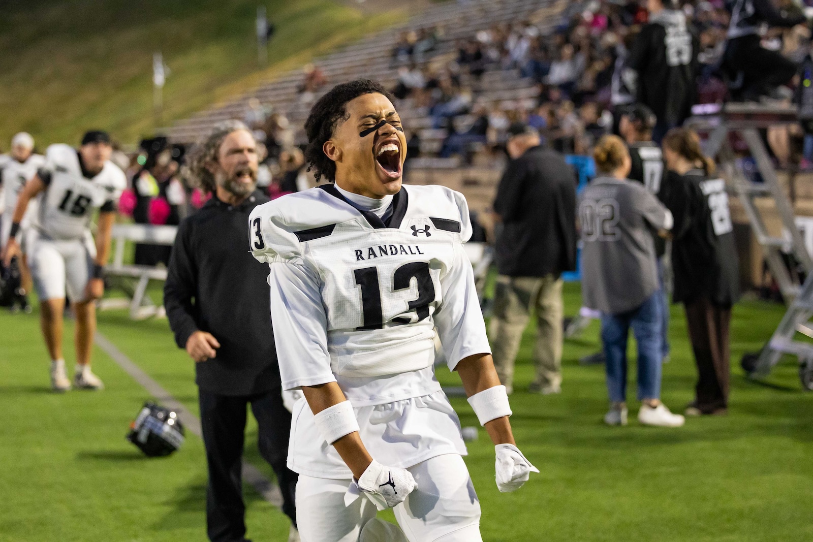 RHS-CHS-FB-9 | Press Pass Sports Football player in white jersey number 13 with'Randall' on chest, shouting with mouth open on a football field.