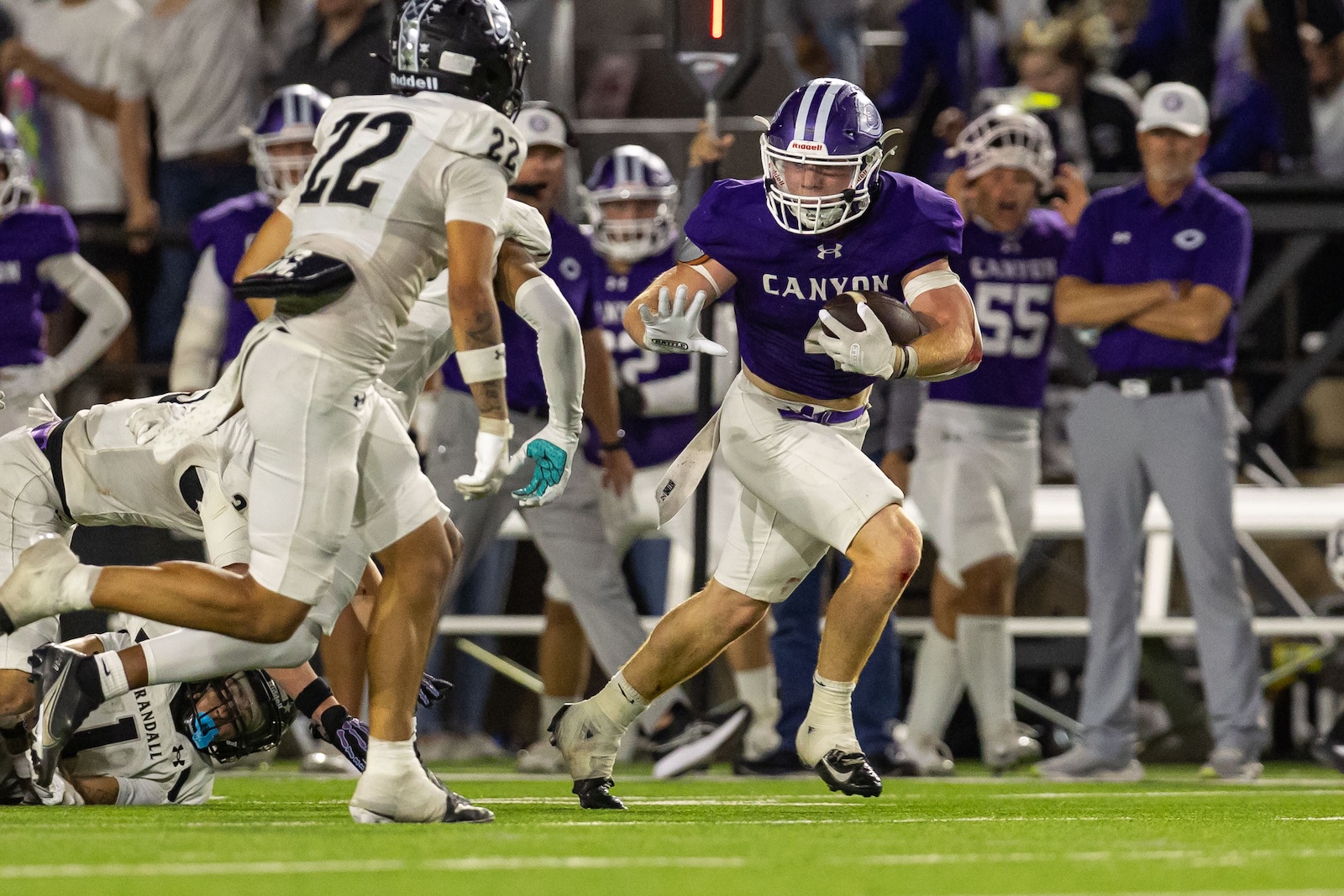 RHS-CHS-FB-33 | Press Pass Sports Canyon quarterback-style player in purple jersey runs with the ball while defenders in white converge.