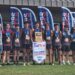 9550 | Press Pass Sports Group of boys in gray and black cross‑country uniforms wearing medals, posing with a banner that says CROSS COUNTRY CHAMPION behind them.