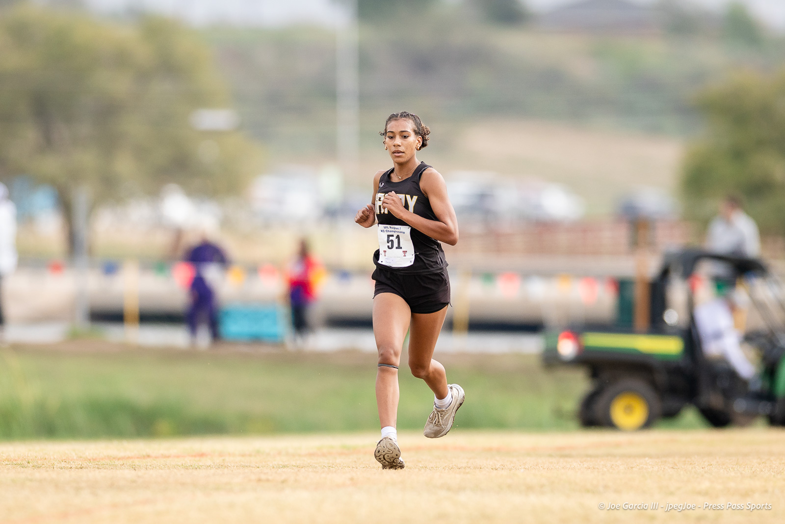 regional-xc-lubbock-2026-jpegJoe-pps-10 | Press Pass Sports Female sprinter in a black uniform running on a track, bib number 51, during a race.